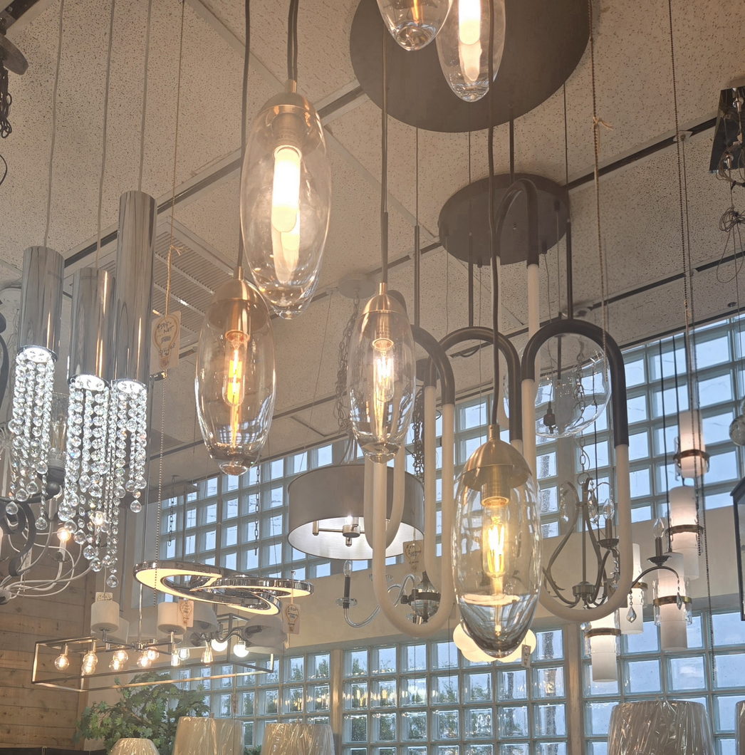 Hand-blown glass pendant lights glowing over the Wholesale Lighting showroom floor in Daytona Beach